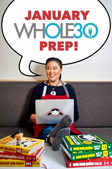 A smiling Asian woman with a laptop and Nom Nom Paleo cookbooks near her has a word bubble that says, "January Whole30 Prep!"