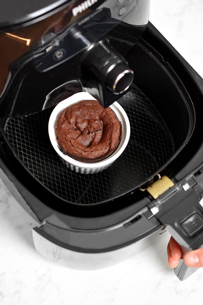 An overhead shot of an open air fryer with a cooked lava cake inside.