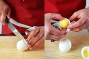 Someone cutting a hard cooked egg in half and separating the yolk from the white.
