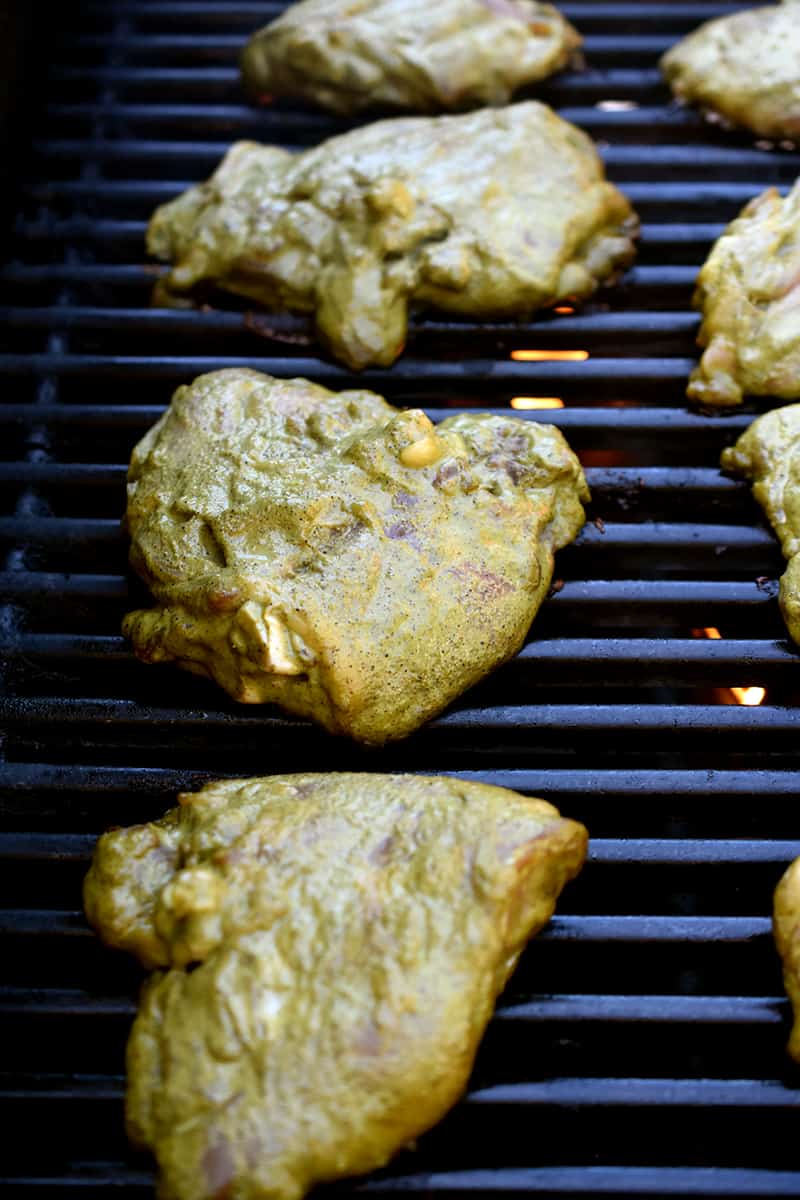 An overhead shot of chicken thighs, skin side down on a hot grill.