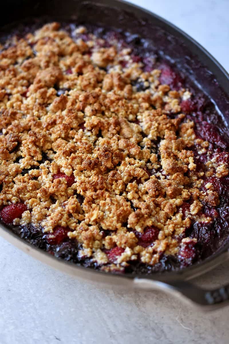 Side shot of a berry crisp right out of the oven.