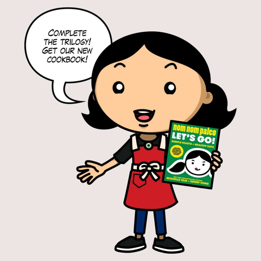 Cartoon of Michelle holding Nom Nom Paleo: Let's Go cookbook and saying "Complete the trilogy! Get our new cookbook!"