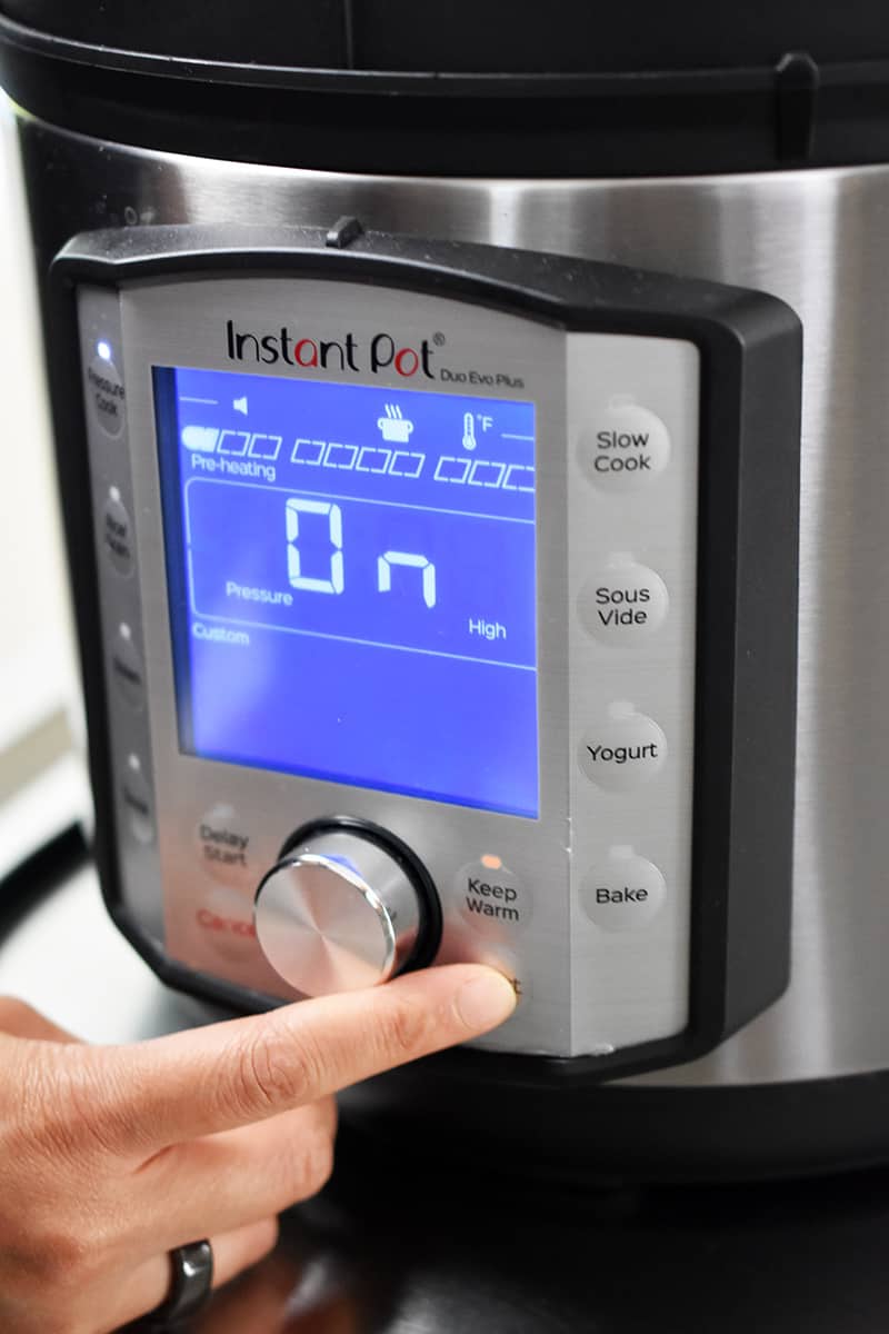 A finger is touching the display on an Instant Pot