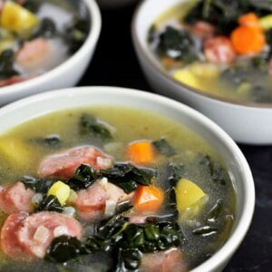 A shot of four bowls filled with sausage and kale soup that can be made in the Instant Pot or on the stovetop.