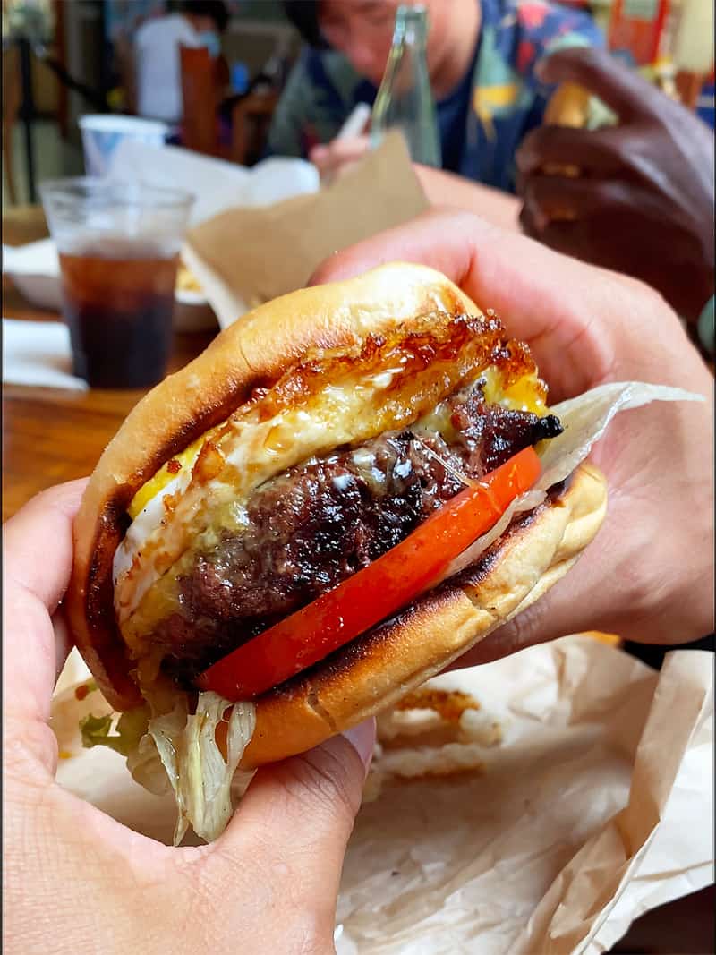 Closeup shot of a gluten-free cheeseburger from Village Burger Kamuela on the Big Island