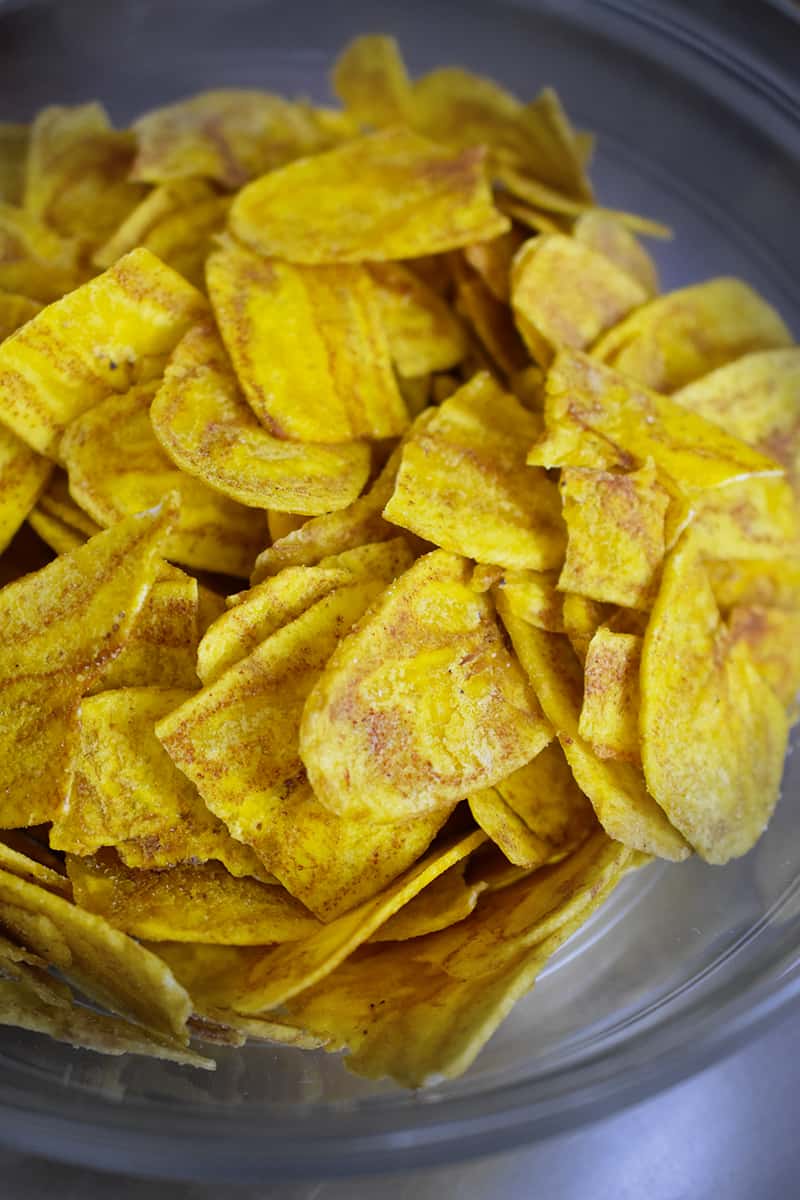 An overhead shot of a bowl of plantain chips and plantain strips.