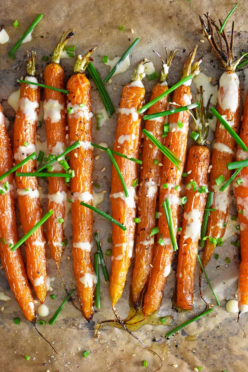 An overhead shot of air fryer roasted carrots topped with ginger sesame dressing and fresh chives.