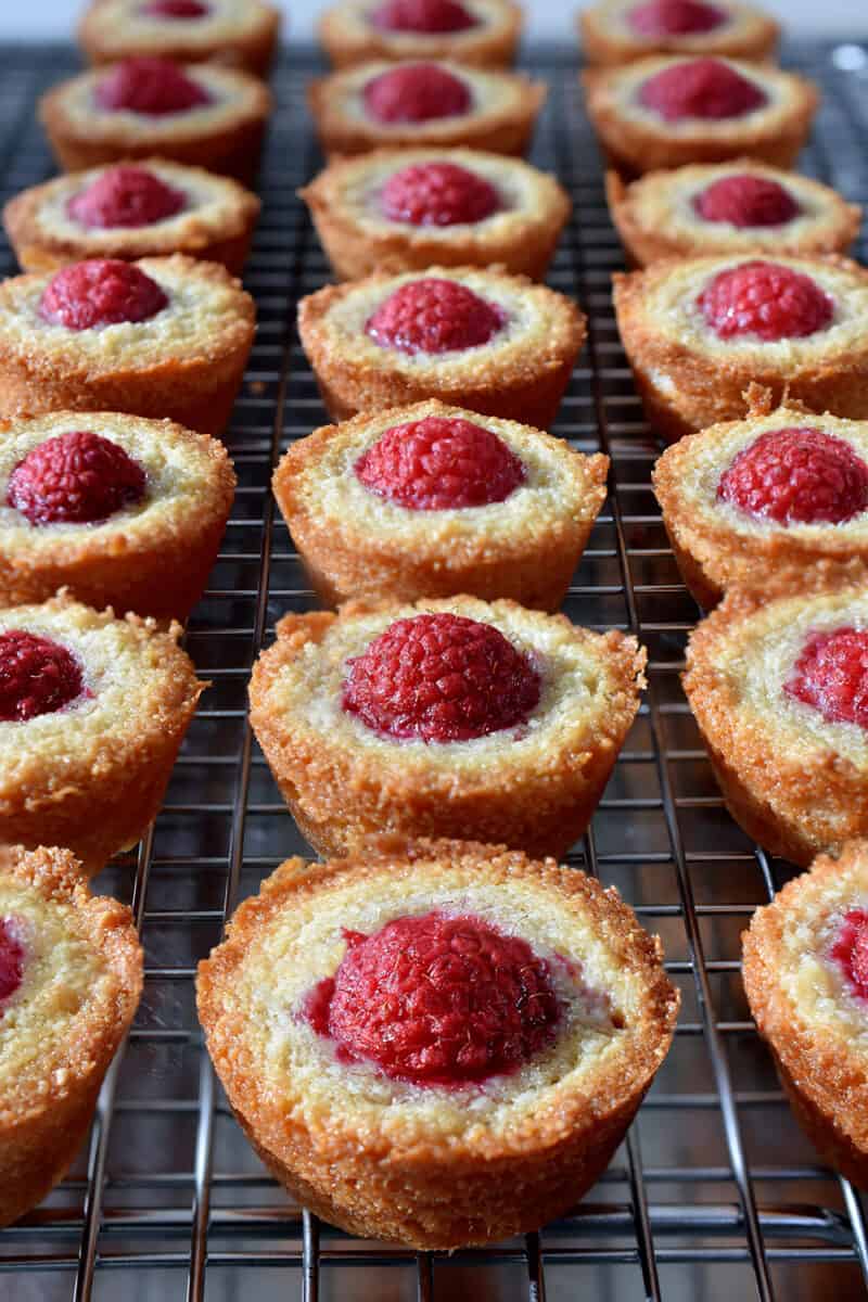 A close up of paleo and gluten free raspberry financiers on a cooling rack