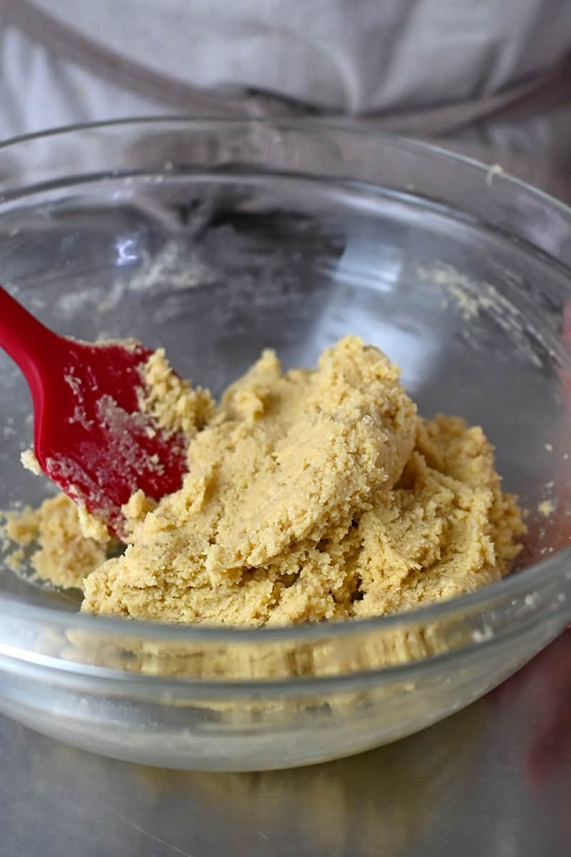 Mixing the paleo cookie dough in a glass bowl with a red silicone spatula