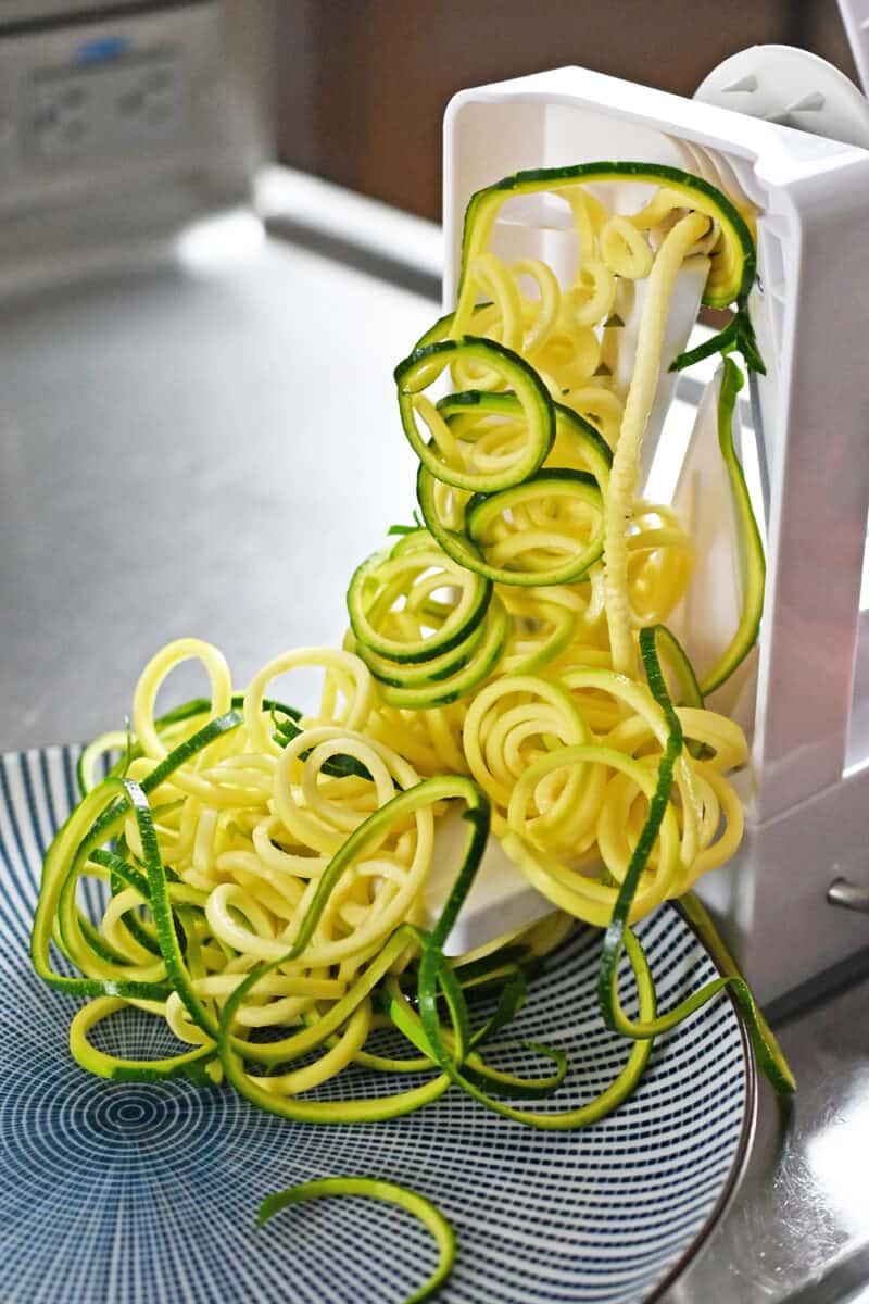 A spiralizer is making zucchini noodles.