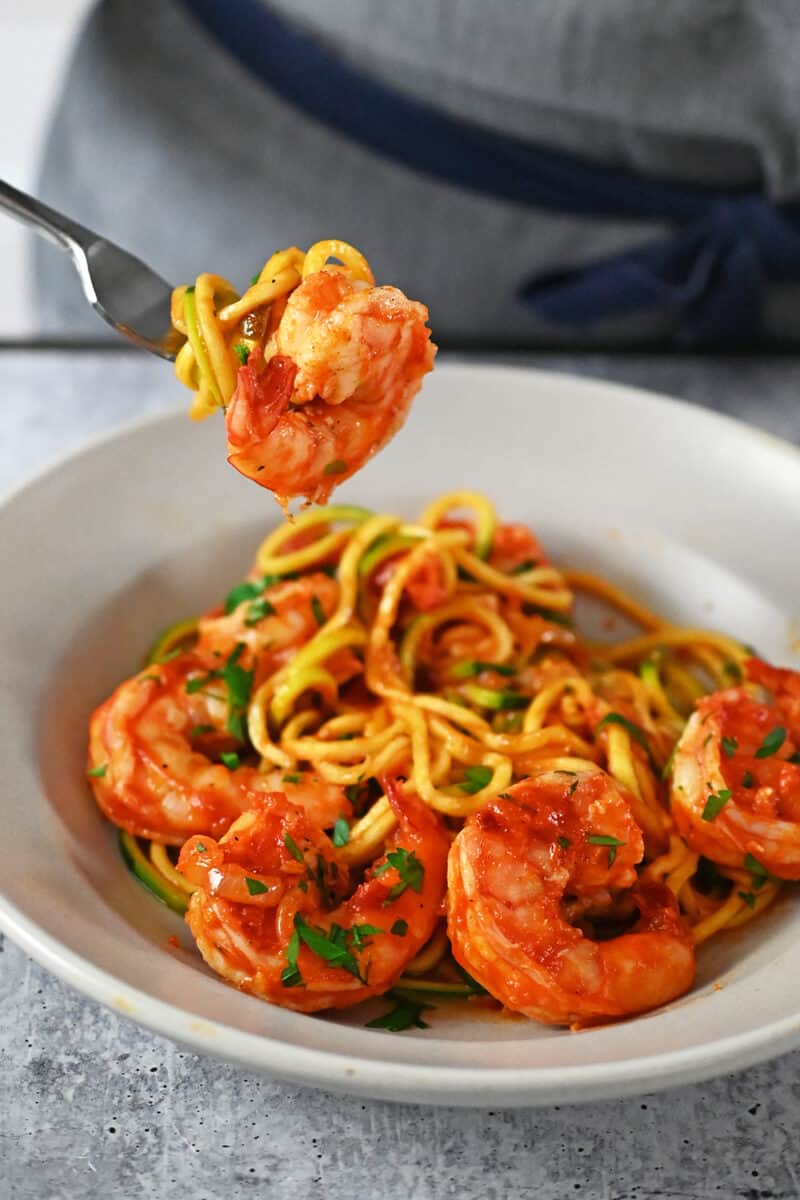 A fork taking a bite of spicy shrimp pasta