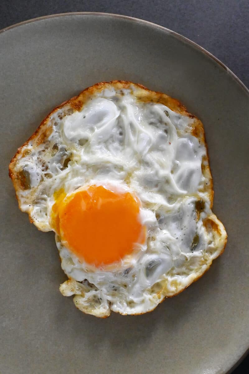 A SUNNYSIDE egg on a plate with crispy edges on the whites