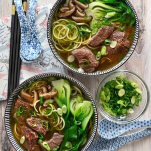An overhead shot of two bowls filled with paleo, Whole30, gluten-free, and keto Chinese beef noodle soup.