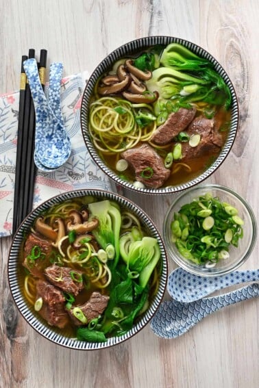 An overhead shot of two bowls filled with paleo, Whole30, gluten-free, and keto Chinese beef noodle soup.