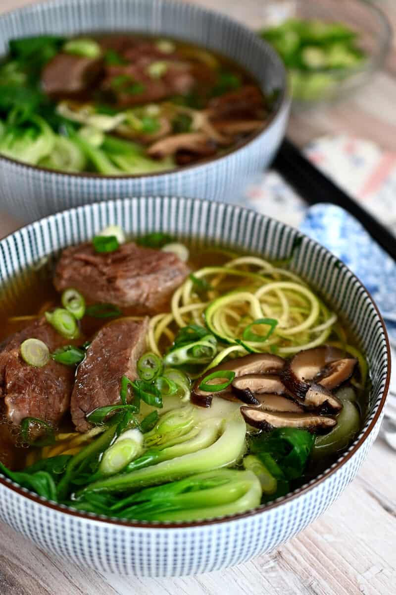 Two bowls of Chinese Beef Noodle Soup, a paleo, Whole30, keto and gluten-free version.