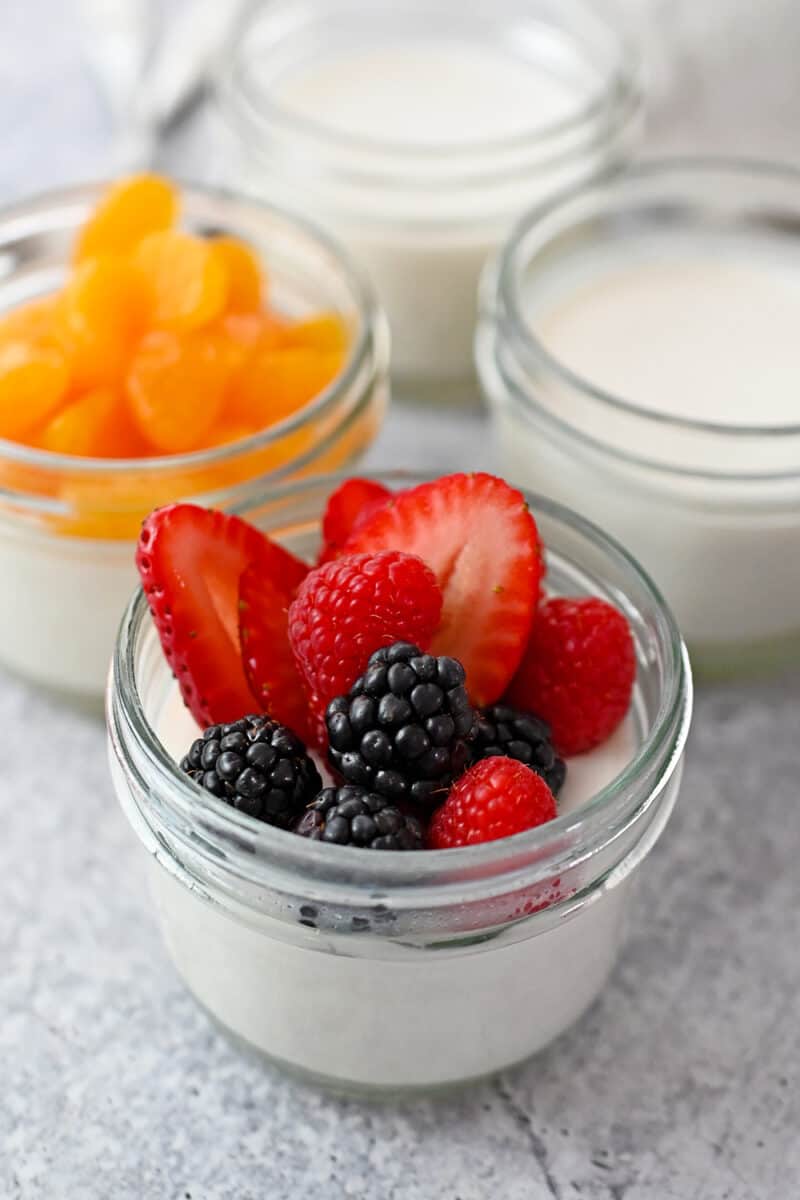 Four jars filled with paleo and dairy free coconut jelly desserts, a dairy-free Melo Melo copycat recipe
