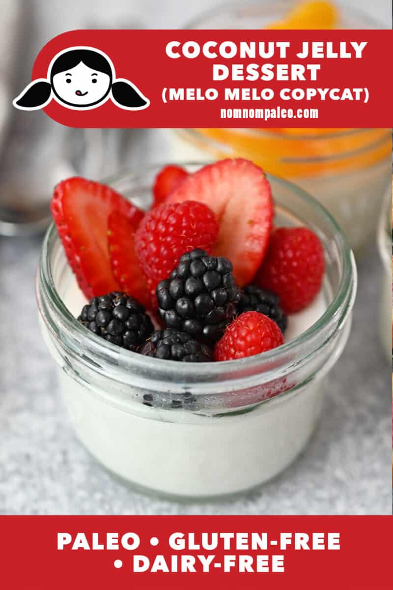 A closeup of a clear jar filled with coconut jelly dessert topped with fresh berries, a Melo Melo copycat recipe that is paleo, gluten-free, and dairy-free
