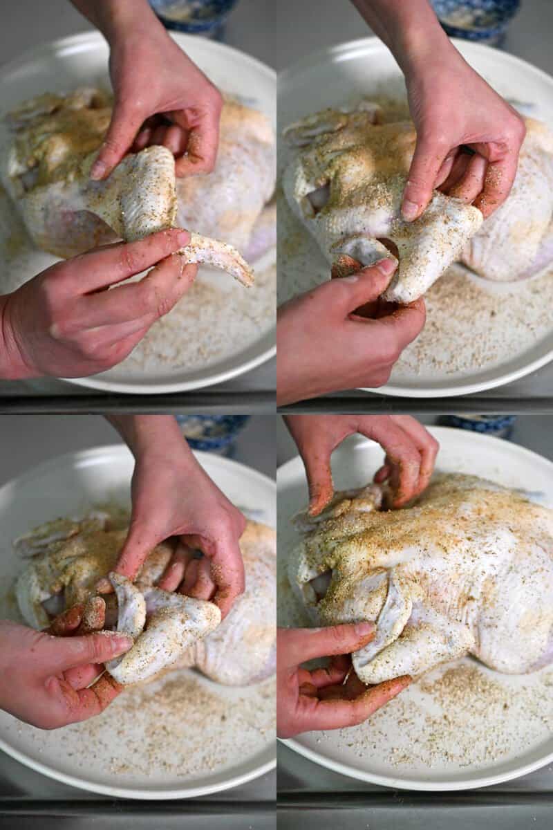 Tucking the wings behind the back of a raw chicken