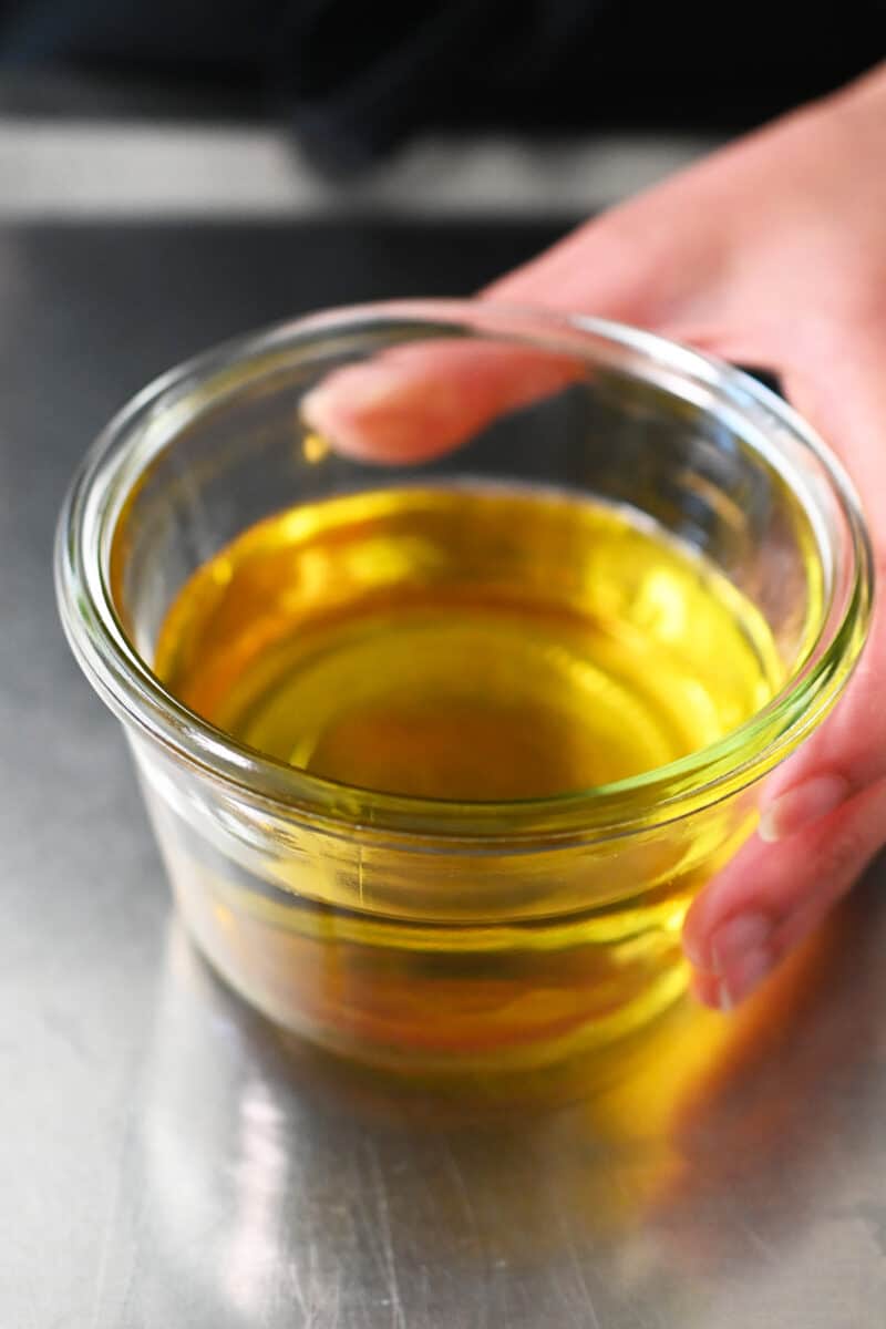 An open glass jar filled with shallot oil.