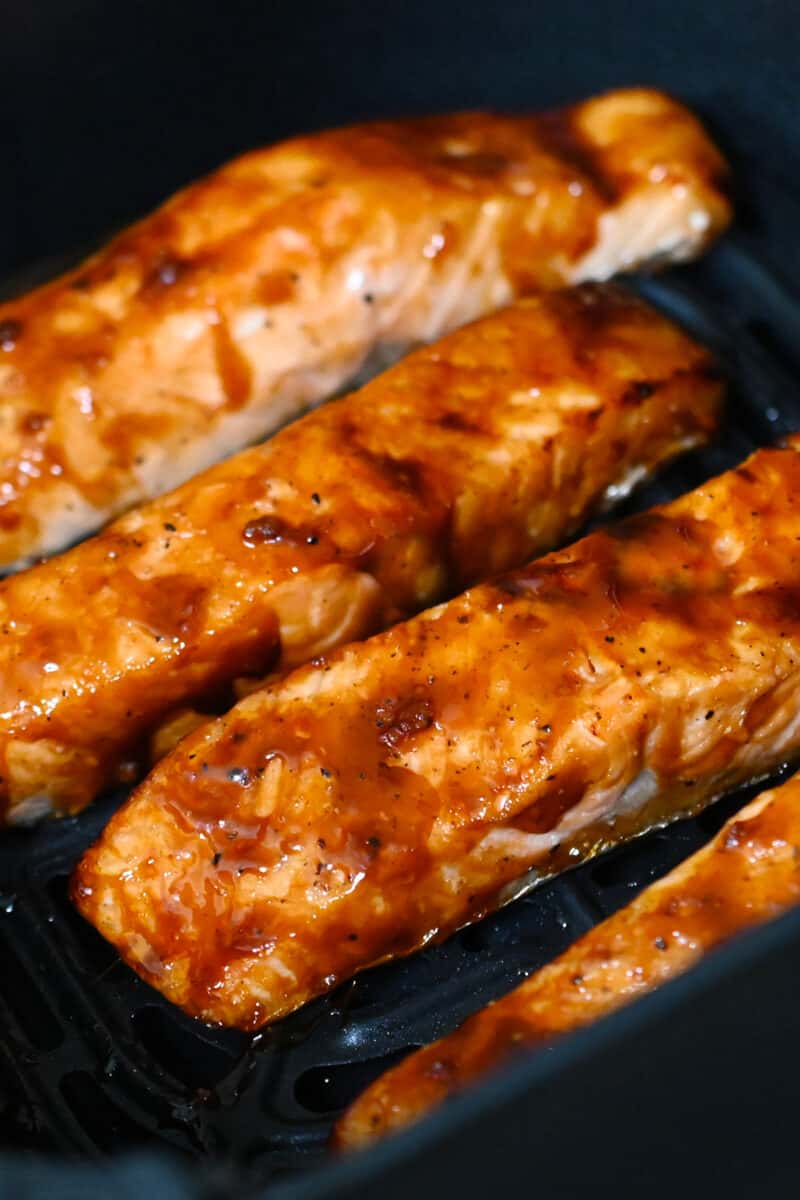 Air fryer salmon with sriracha ginger glaze in an open air fryers ready to eat.