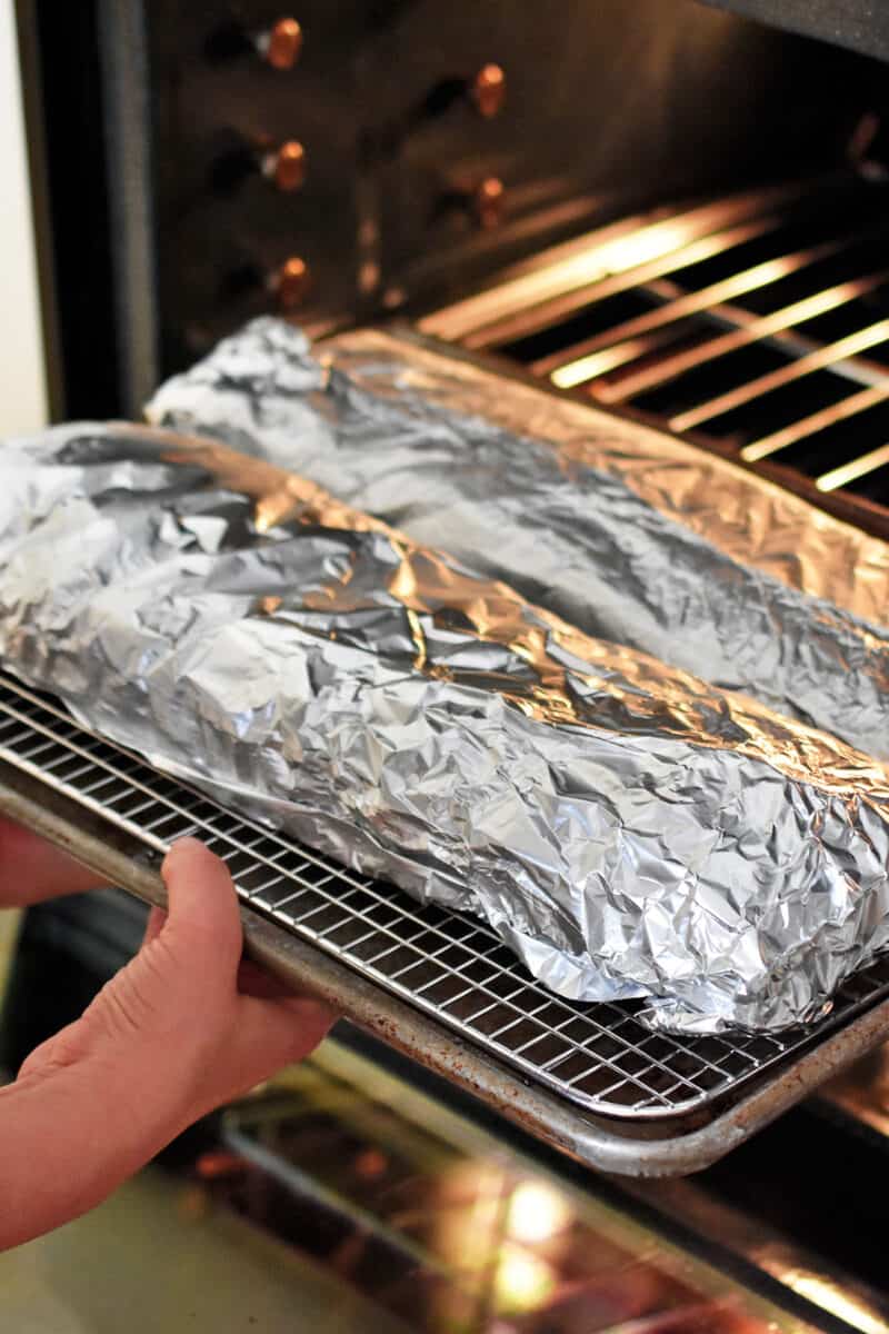 The foil wrapped baby back ribs are placed in an oven.