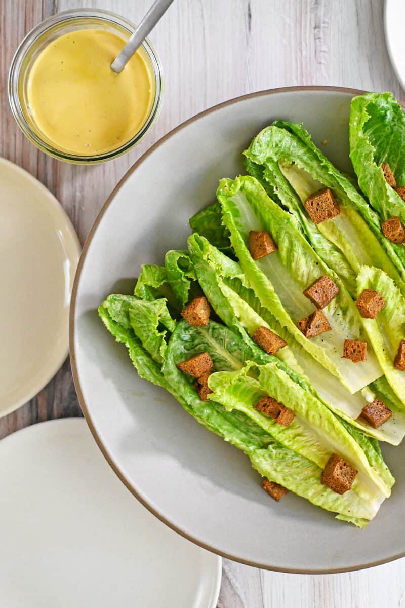 A paleo dairy free Caesar salad with gluten-free croutons on a platter.
