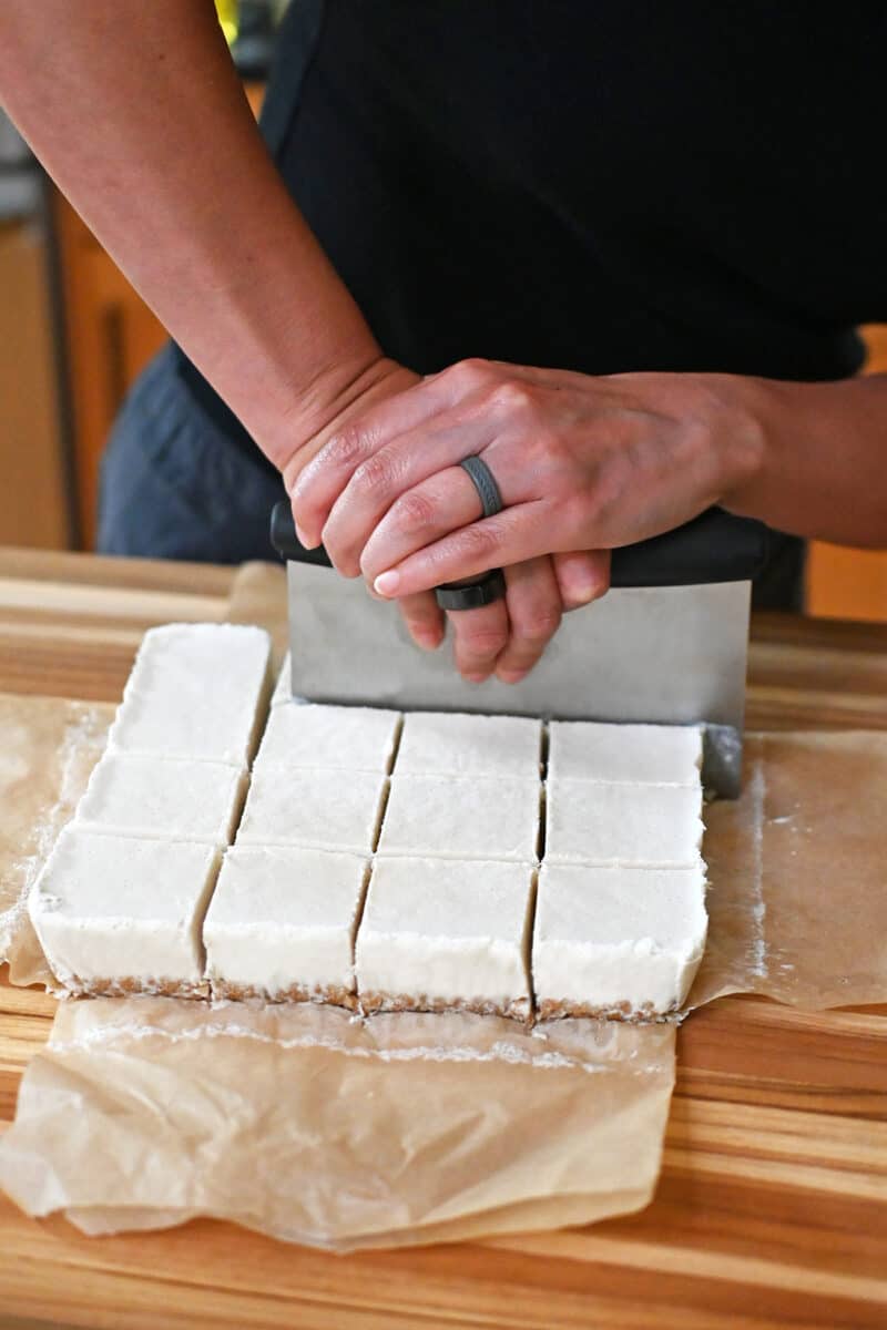Cutting coconut cream bars with a pastry cutter.