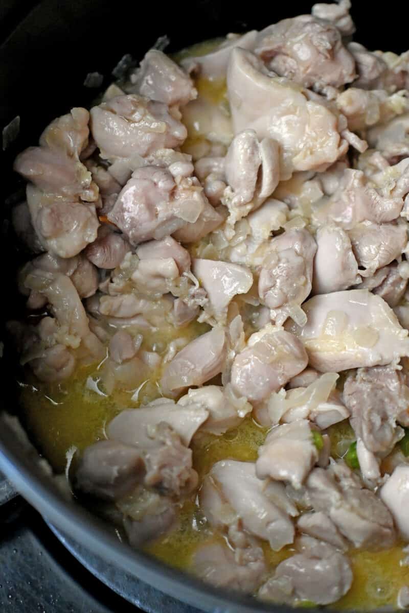 An overhead shot of cooked cut-up chicken thighs that are no longer pink.