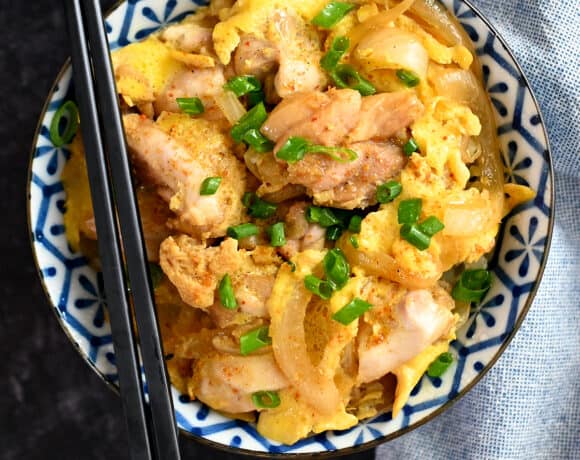 An overhead shot of a bowl filled with paleo and low carb oyakodon with a pair of black chopsticks on the bowl.
