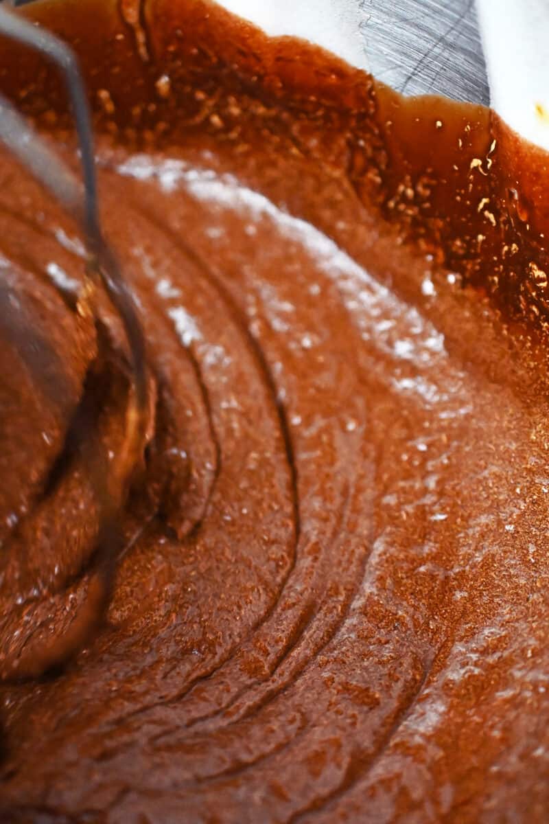 An overhead shot of a mixing bowl filled with a chocolate batter to make Torta Caprese.