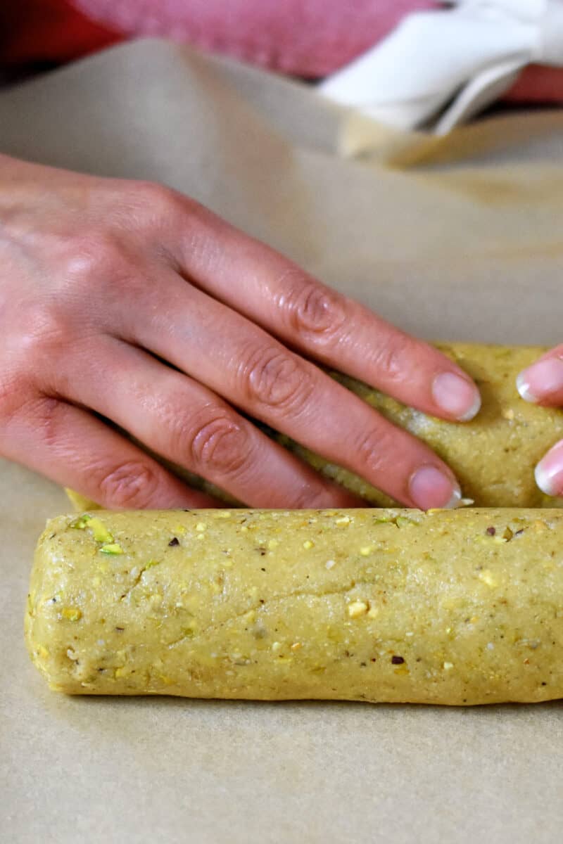 Raw pistachio cookie dough rolled into a log.