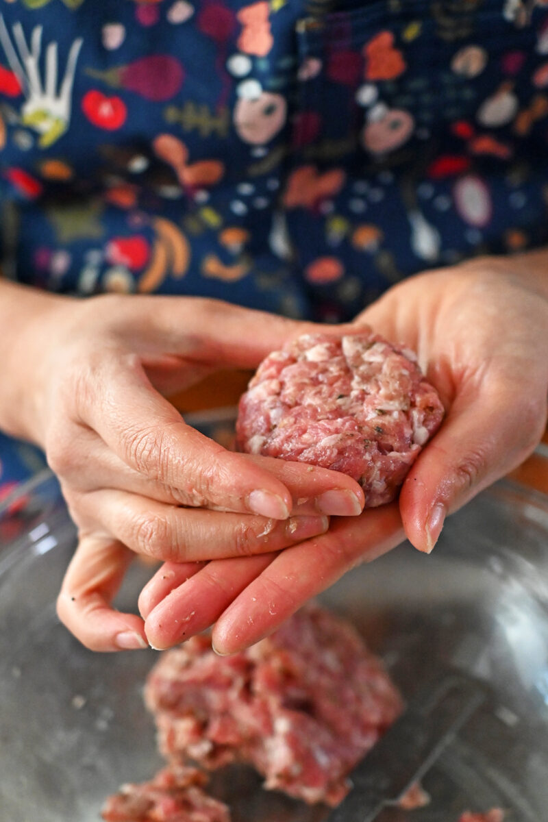Forming a sausage patty with two hands.