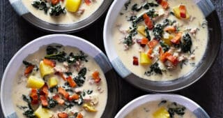 An overhead shot of four bowls of dairy-free Zuppa Toscana.