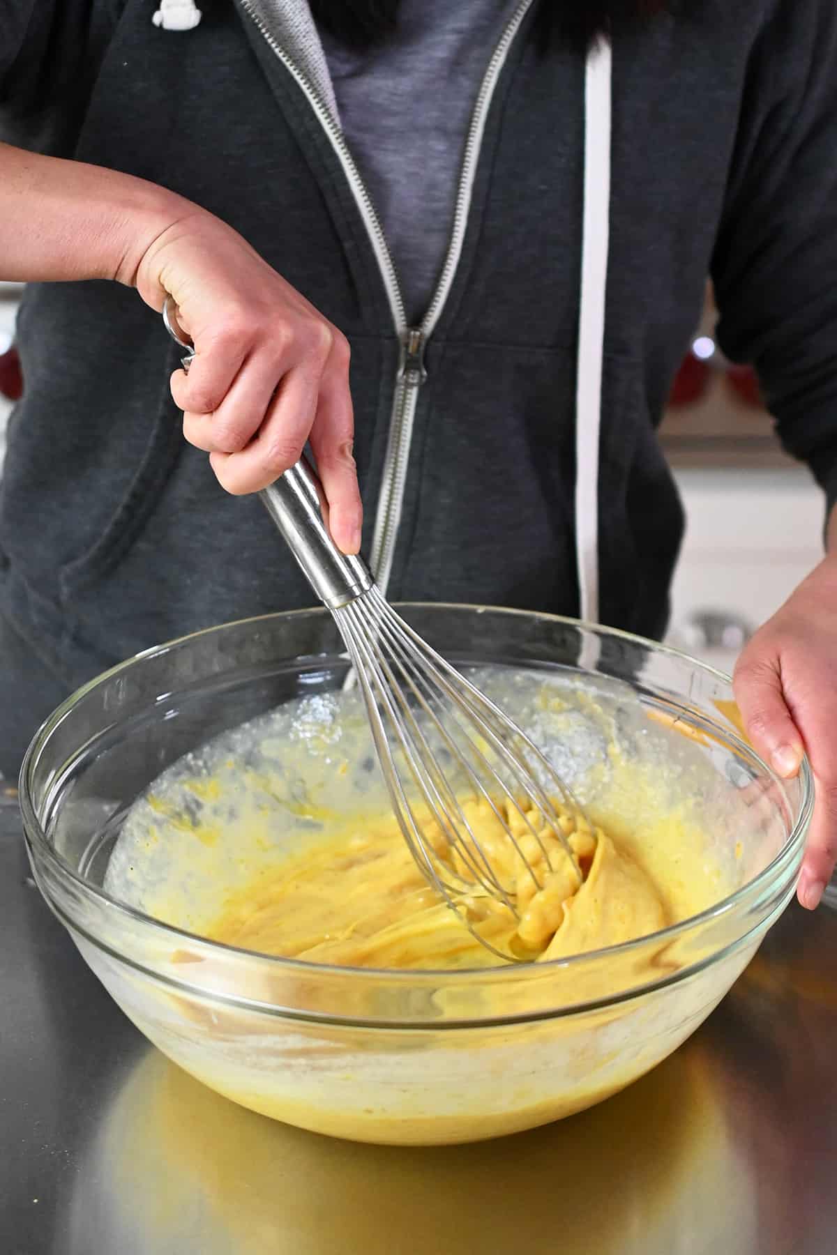 Whisking the dairy-free and paleo quiche filling in a large mixing bowl.