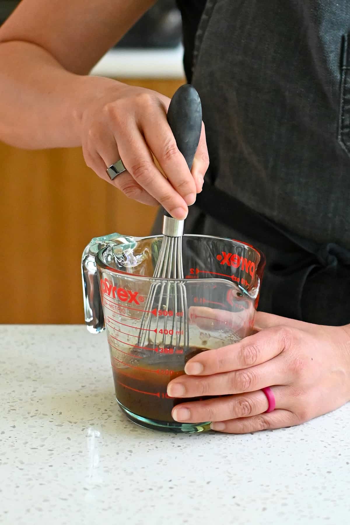 Whisking arrowroot powder into All-Purpose Stir-Fry Sauce in a liquid measuring cup.