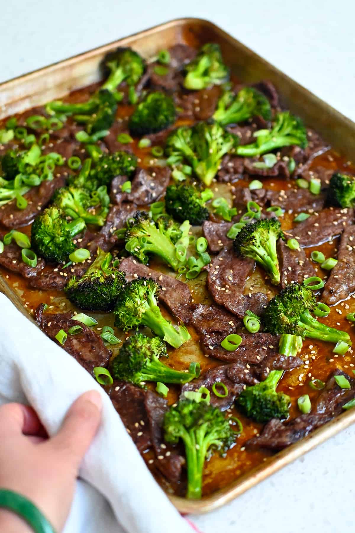 A side view of a ready to serve sheet pan beef and broccoli.