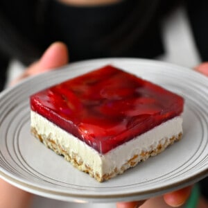 A slice of grain-free, gluten-free, and dairy-free strawberry pretzel salad on a white plate.