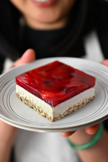 A slice of grain-free, gluten-free, and dairy-free strawberry pretzel salad on a white plate.