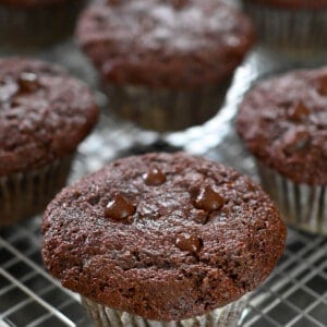 A closeup of paleo chocolate zucchini muffins on a wire cooling rack.