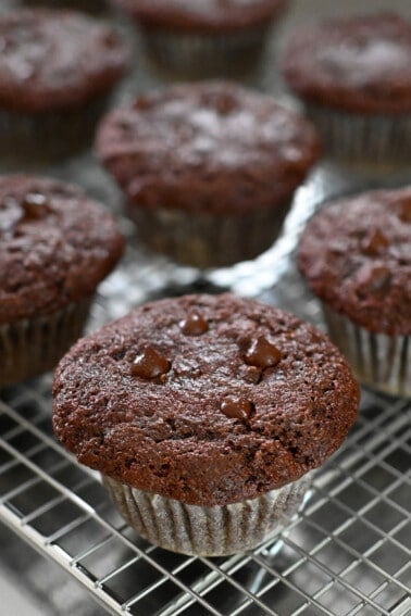 A closeup of paleo chocolate zucchini muffins on a wire cooling rack.