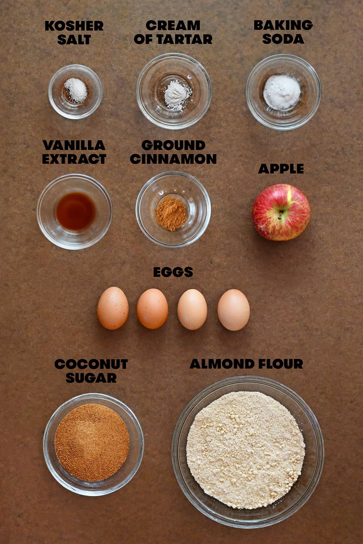 Raw ingredients for apple muffins are measured out in bowls.