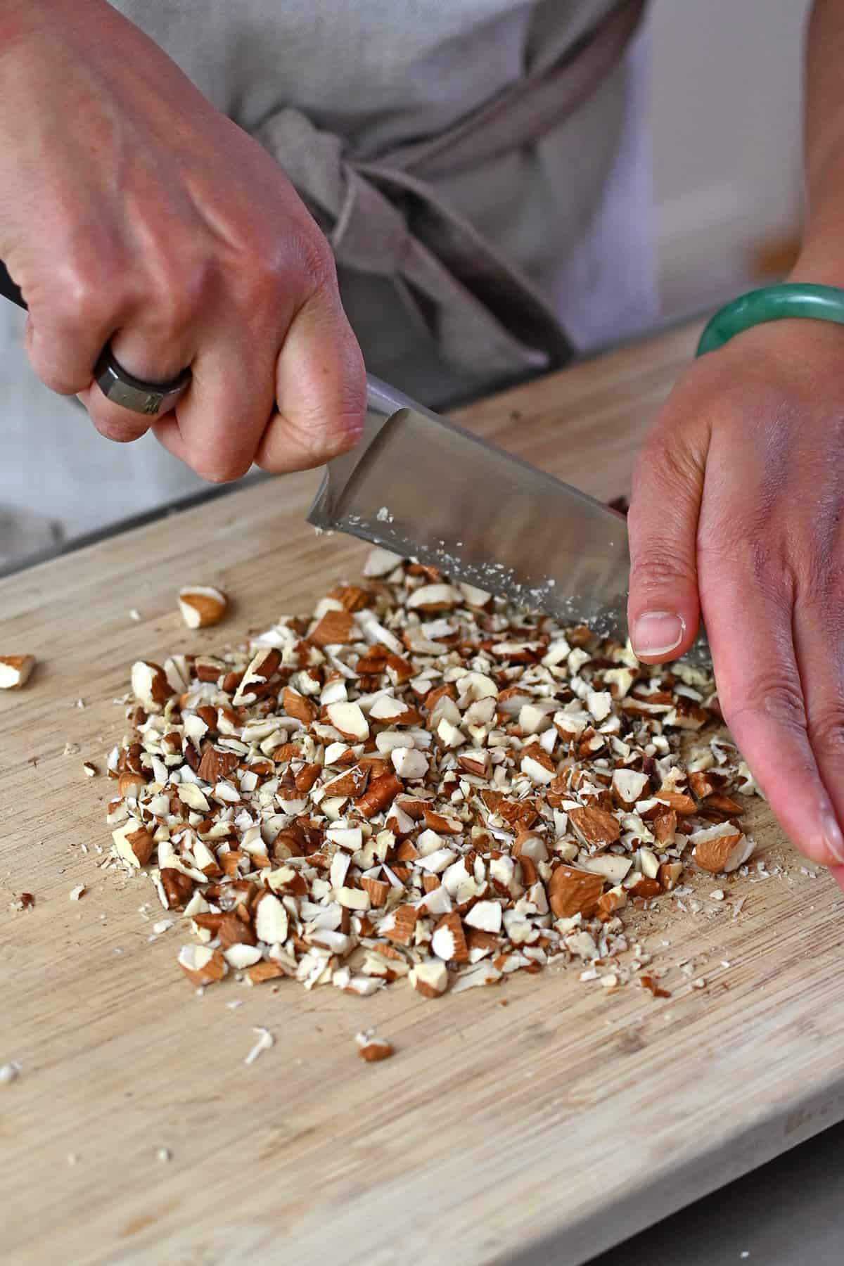 Chopping almonds and pecans to make the topping for paleo apple muffins.