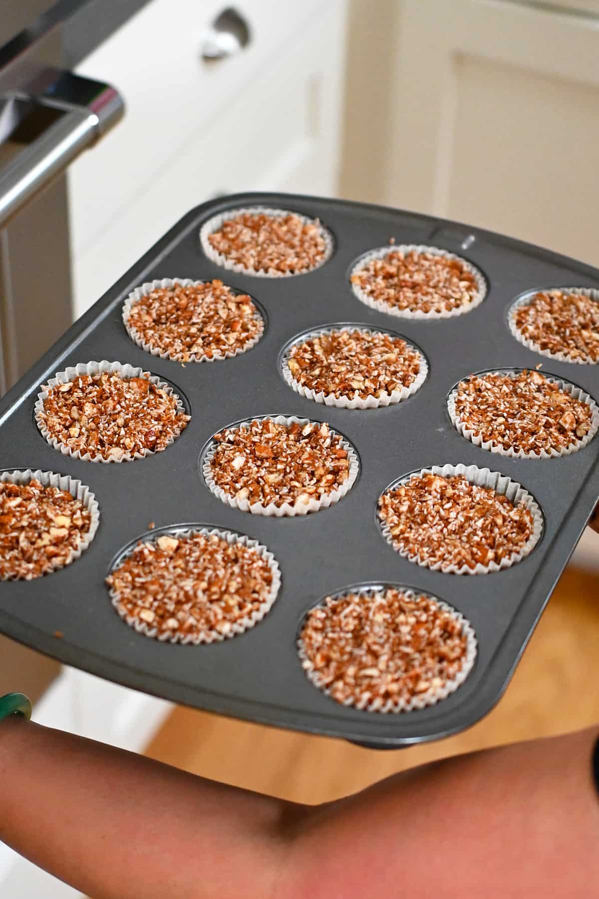Placing a tray of paleo and gluten free apple muffins into the oven.