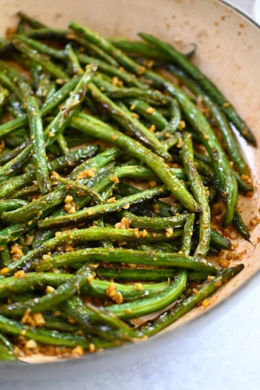 A closeup shot of paleo, Whole30, and gluten free Chinese garlic green beans in a skillet.