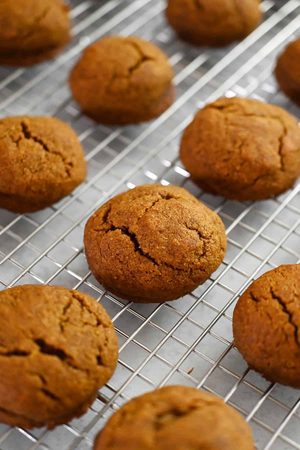 A closeup showing paleo pumpkin cookies cooling on a wire rack.
