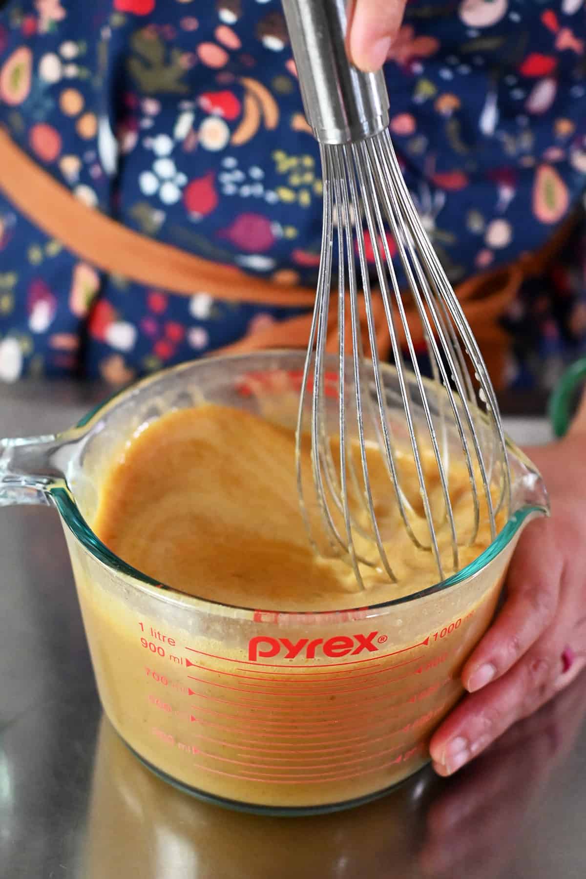 Whisking the ingredients for pumpkin custard in a large measuring cup.