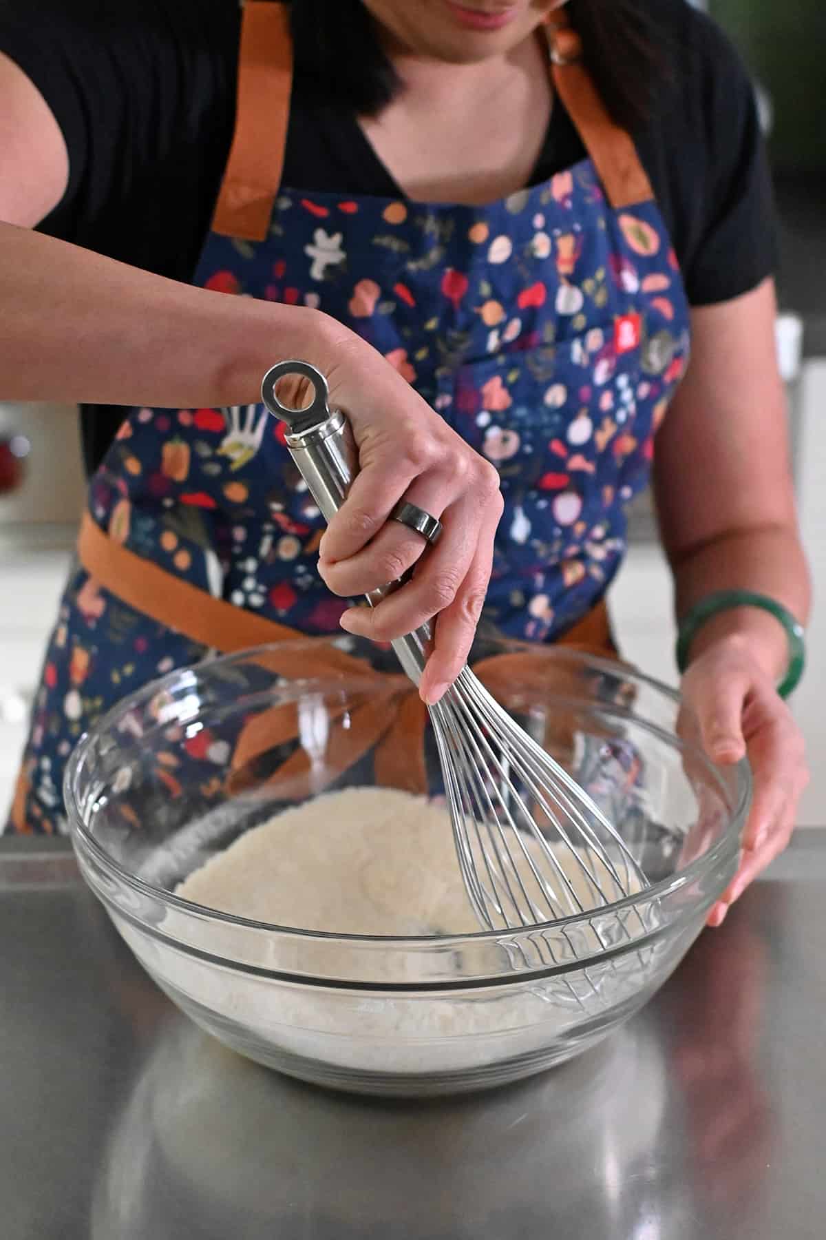 Whisking the dry ingredients for paleo and gluten free snickerdoodles in a large glass mixing bowl.