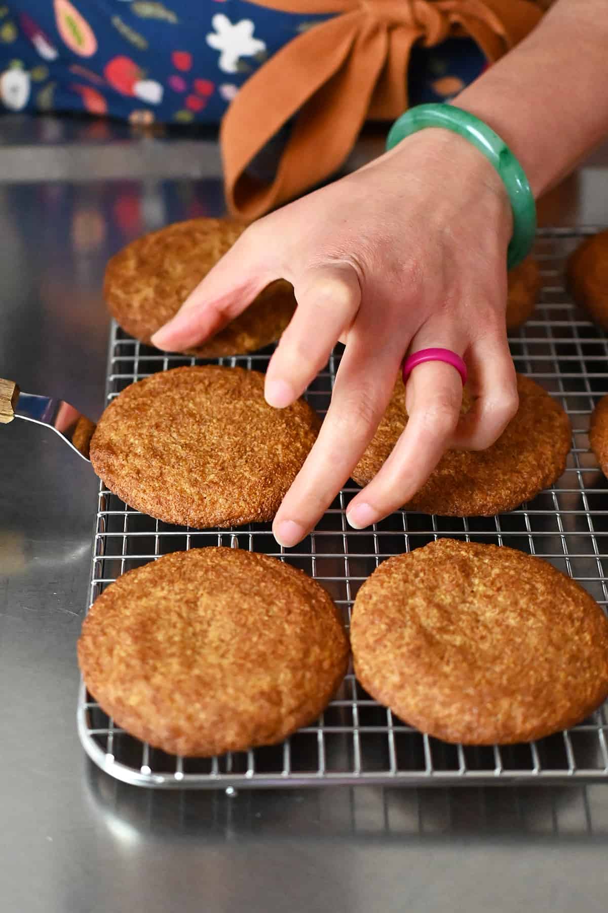 Transferring snickerdoodles to a wire cooling rack with a small offset spatula.