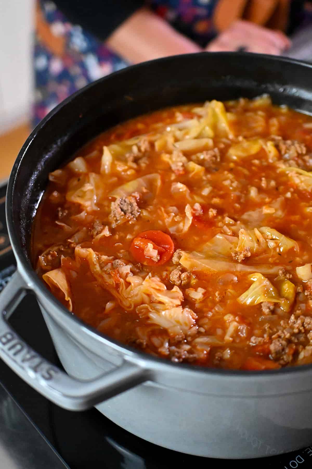 A side view of a gray pot filled with paleo and Whole30 stuffed cabbage soup, or cabbage roll soup.