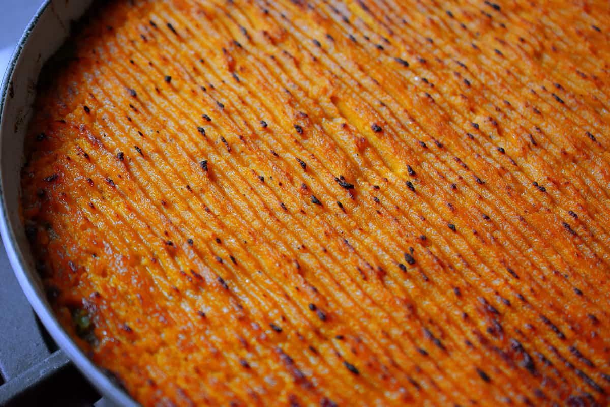 A close up of the browned top of a Indian-spiced shepherd's pie that is ready to serve.